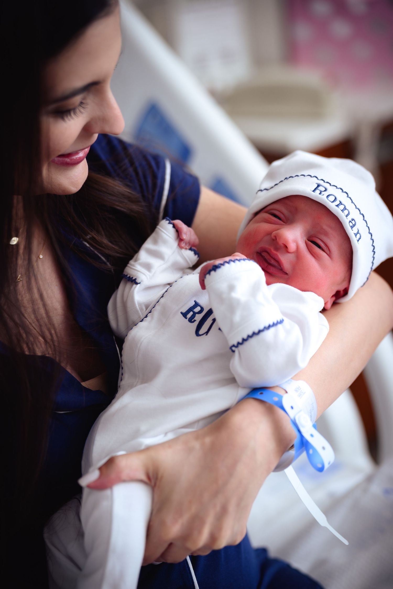 Multiple views of a caregiver in navy blue uniform cradling a swaddled newborn with a pacifier.