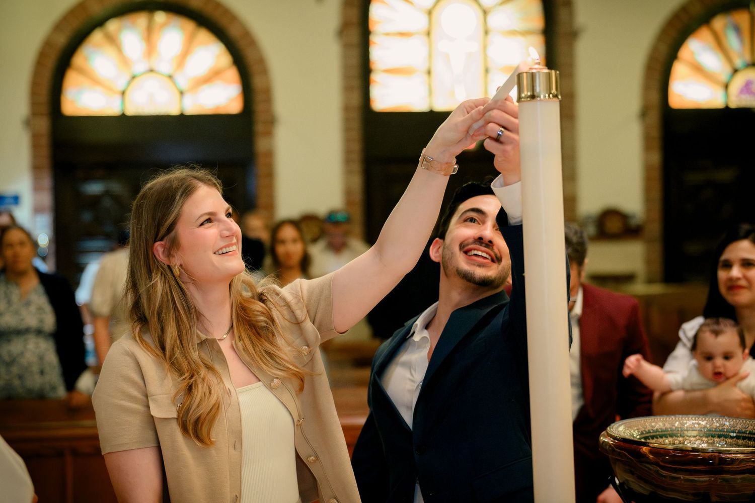 A ceremonial candle lighting during a Catholic baptism at St. Raymond, Coral Gables, Miami FL