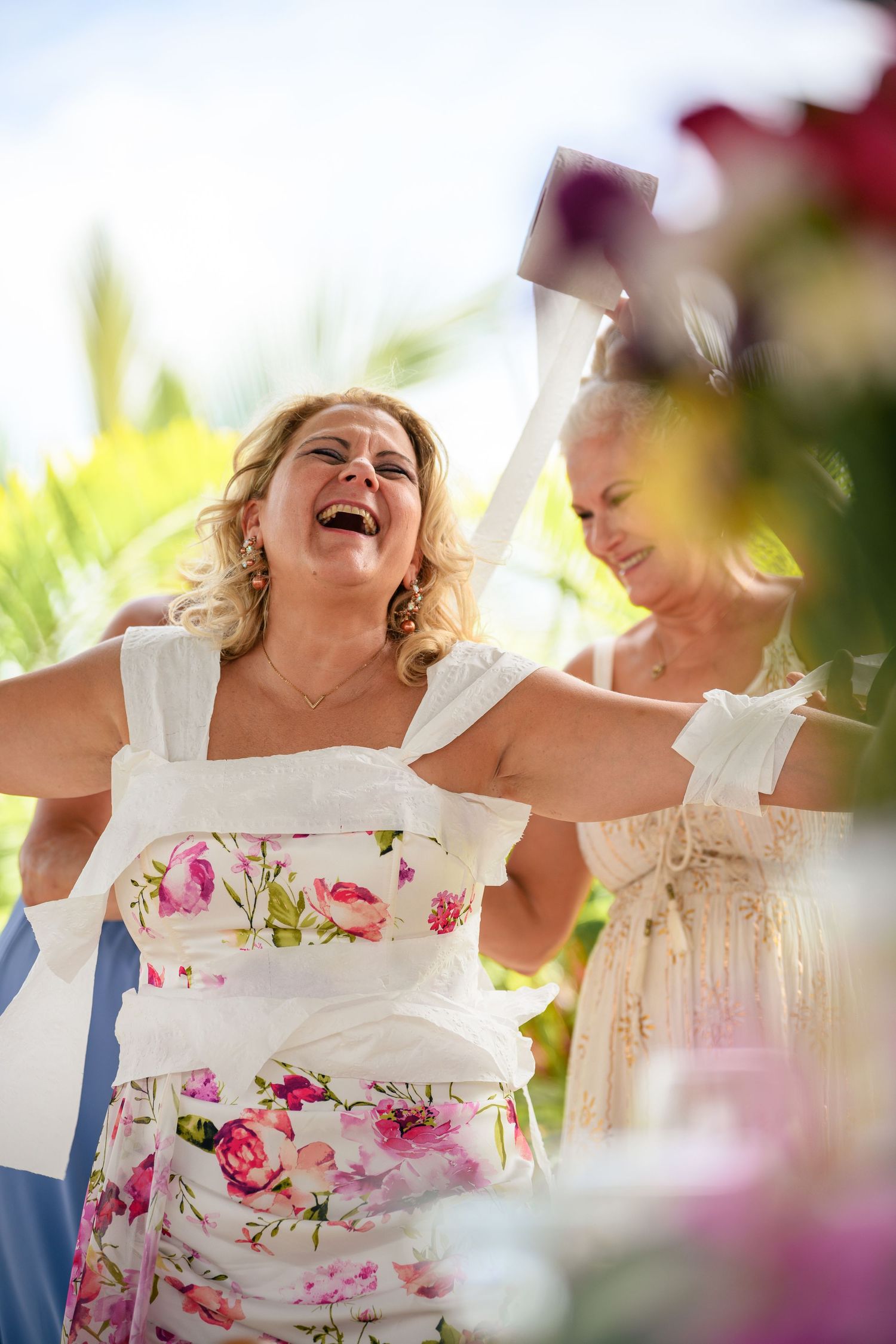 A series of candid photos showing joyful laughter and celebration during a wedding reception with floral decor.