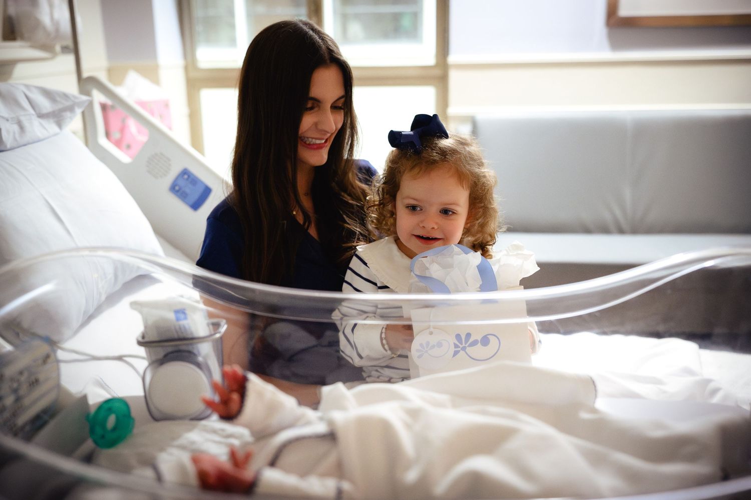 A series of photos showing a newborn baby in hospital being cared for by medical staff and family members.