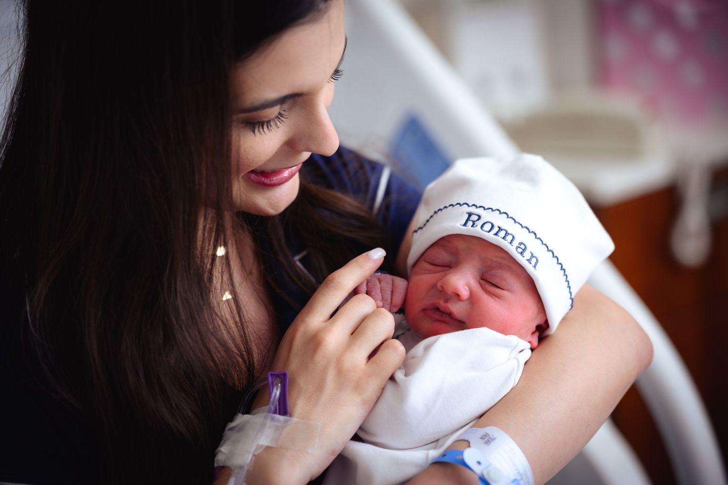 A mother tenderly holds and kisses her newborn baby in a series of heartwarming photographs.