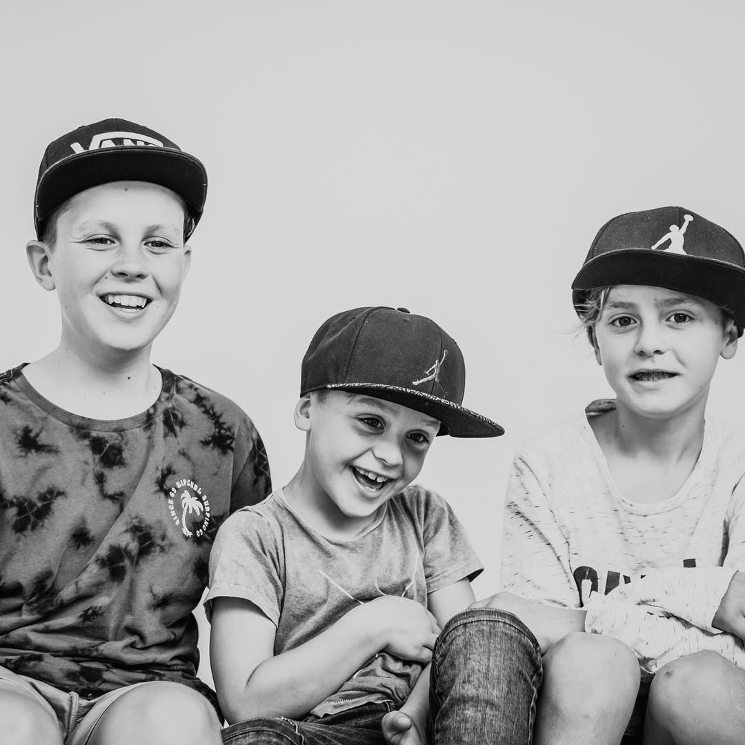 Black and white portrait of three children smiling, natural and relaxed family photography