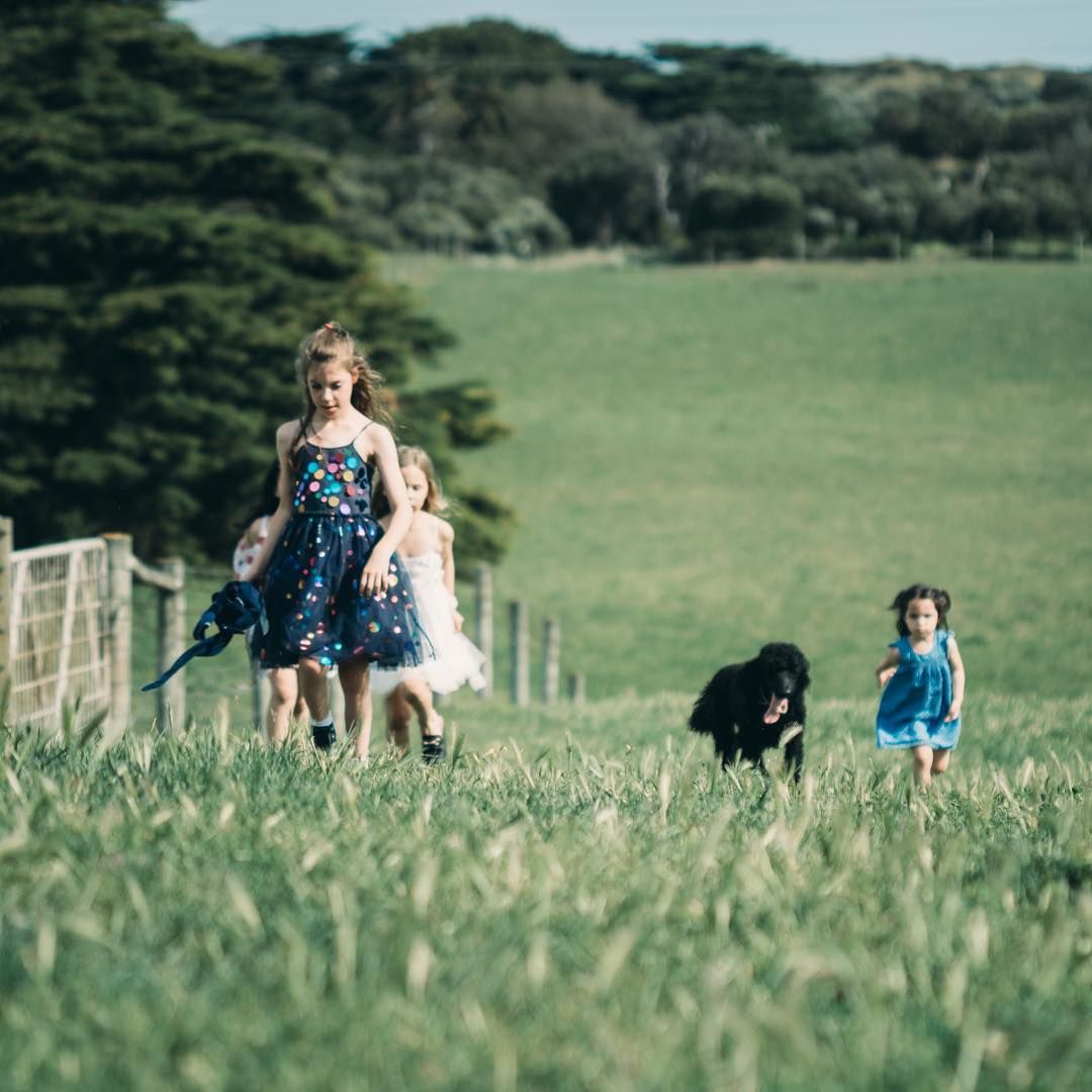 Children walking through open field, natural outdoor family photography in wide landscape
