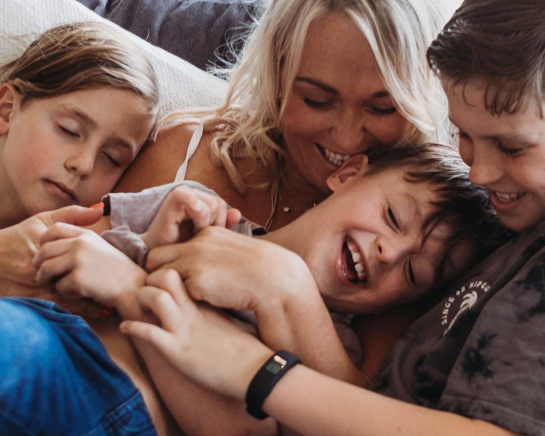 Family laughing together on couch, relaxed in-home family photography session