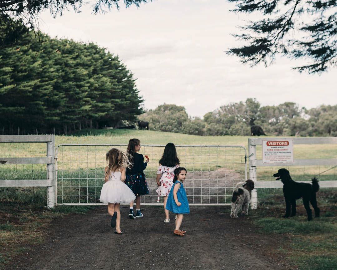 Family walking together through countryside gate, candid outdoor family photography on the Mornington Peninsula
