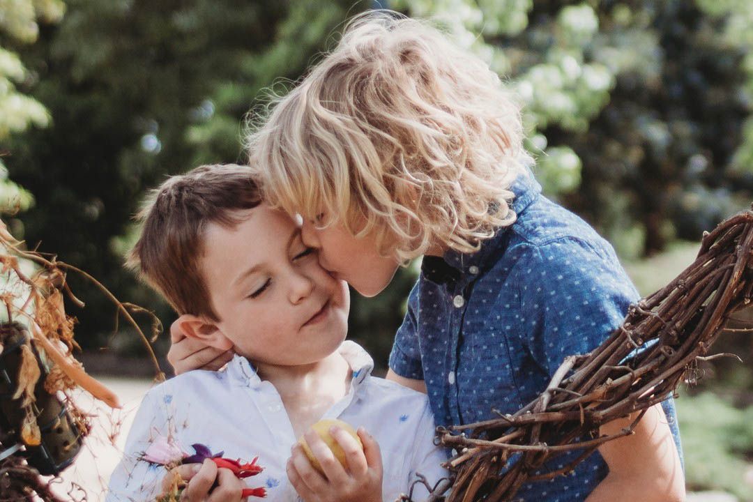 Children sitting close together, candid moment showing connection and emotion