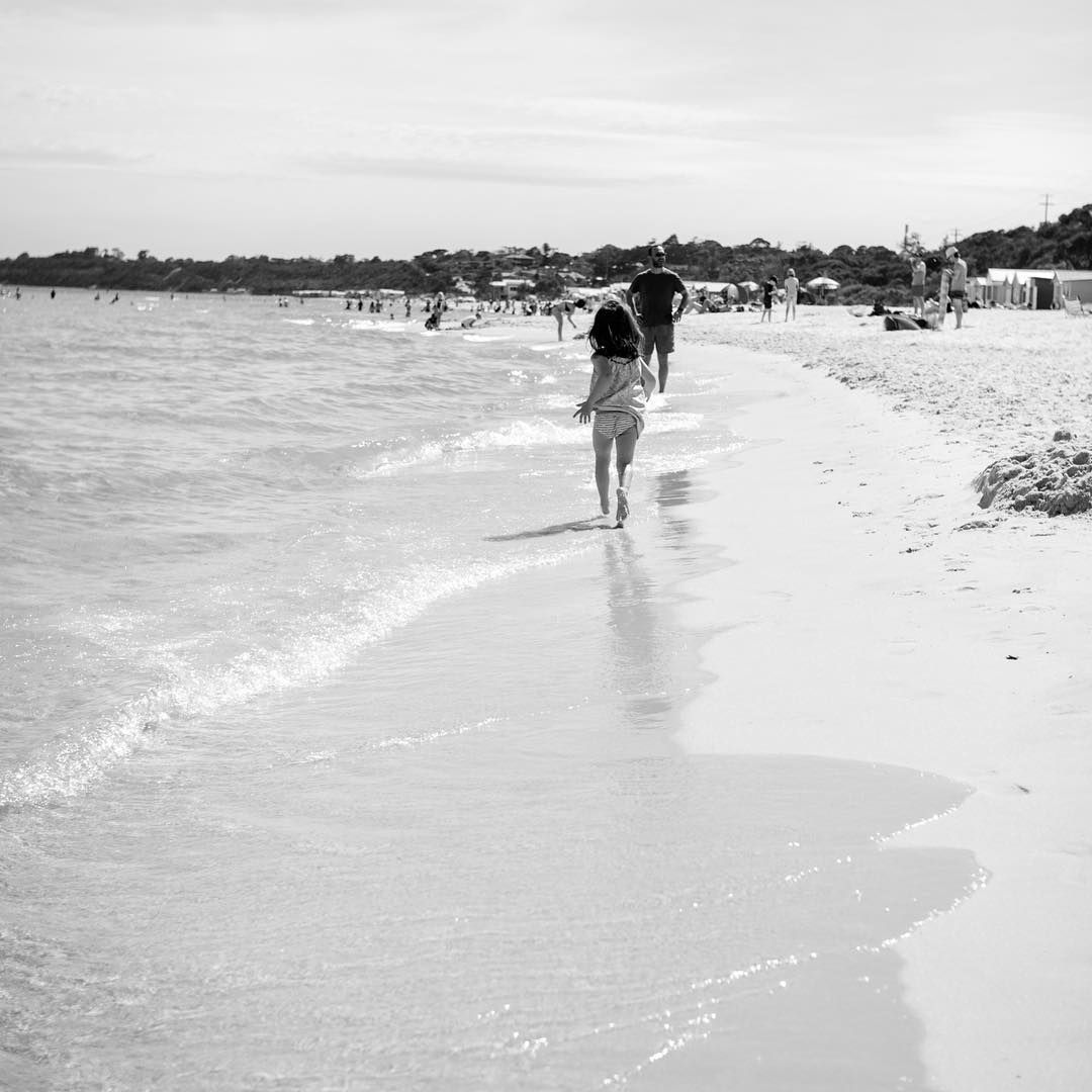 Person walking along beach shoreline, relaxed coastal photography on the Mornington Peninsula