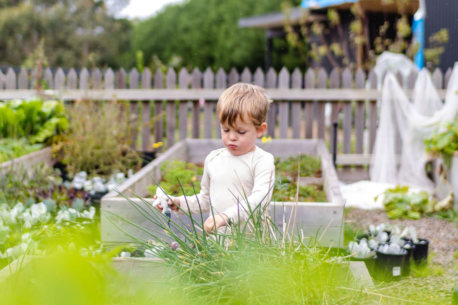 Child playing in garden with watering can, relaxed lifestyle photography in natural outdoor setting