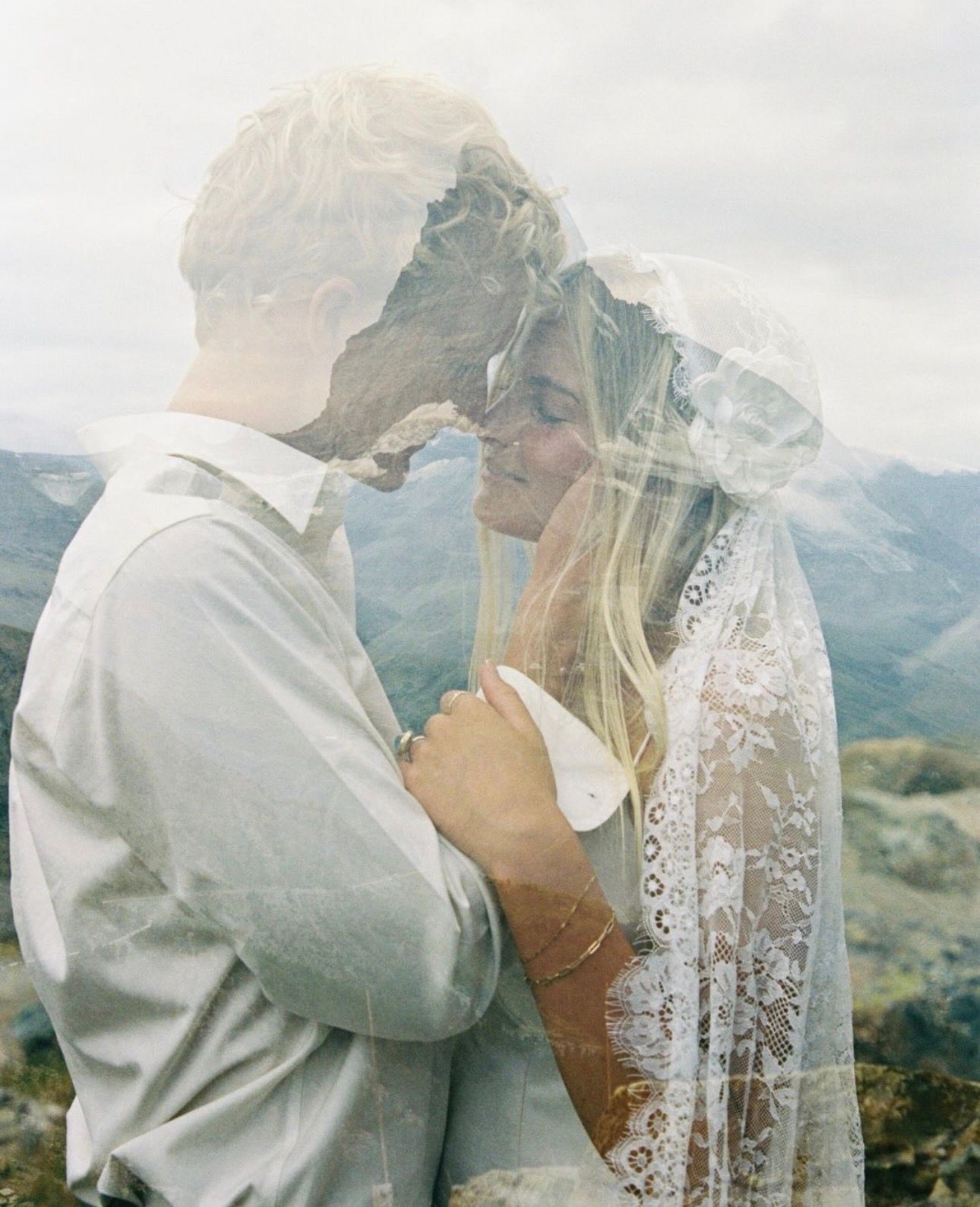 Romantic double exposure portrait of bride and groom nearly kissing beneath a delicate lace veil in Montana Glacier National Park.