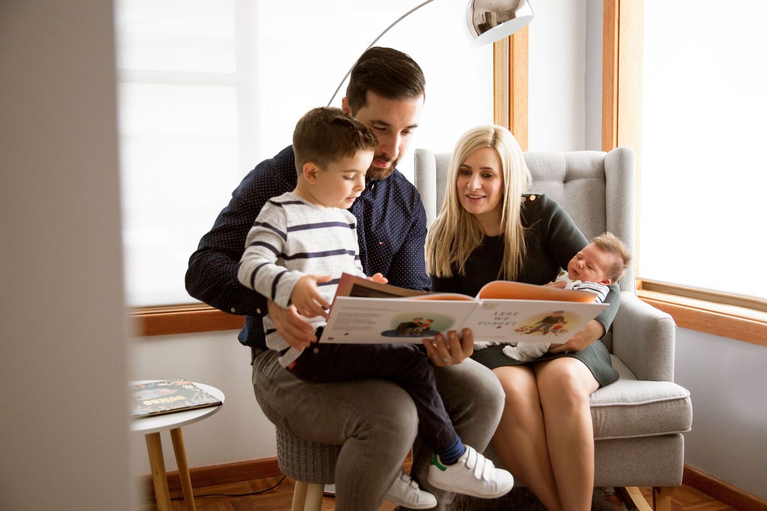 Adelaide in-home lifestyle newborn session — Mum sitting reading with toddler and newborn at home, photographed by Photo by