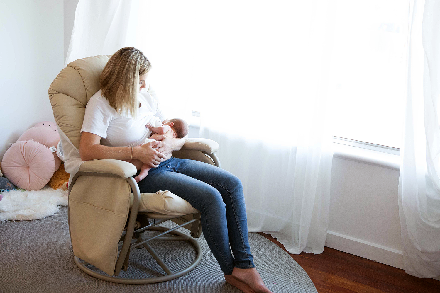 Relaxed in-home newborn photography Adelaide — mum feeding her newborn in natural light at home, photographed by Photo by Nancy