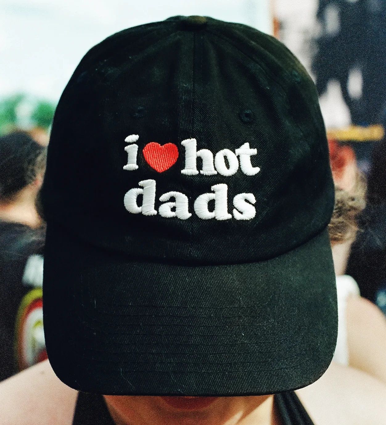 Black baseball cap with white embroidered text reading i love hot dads with a red heart symbol.