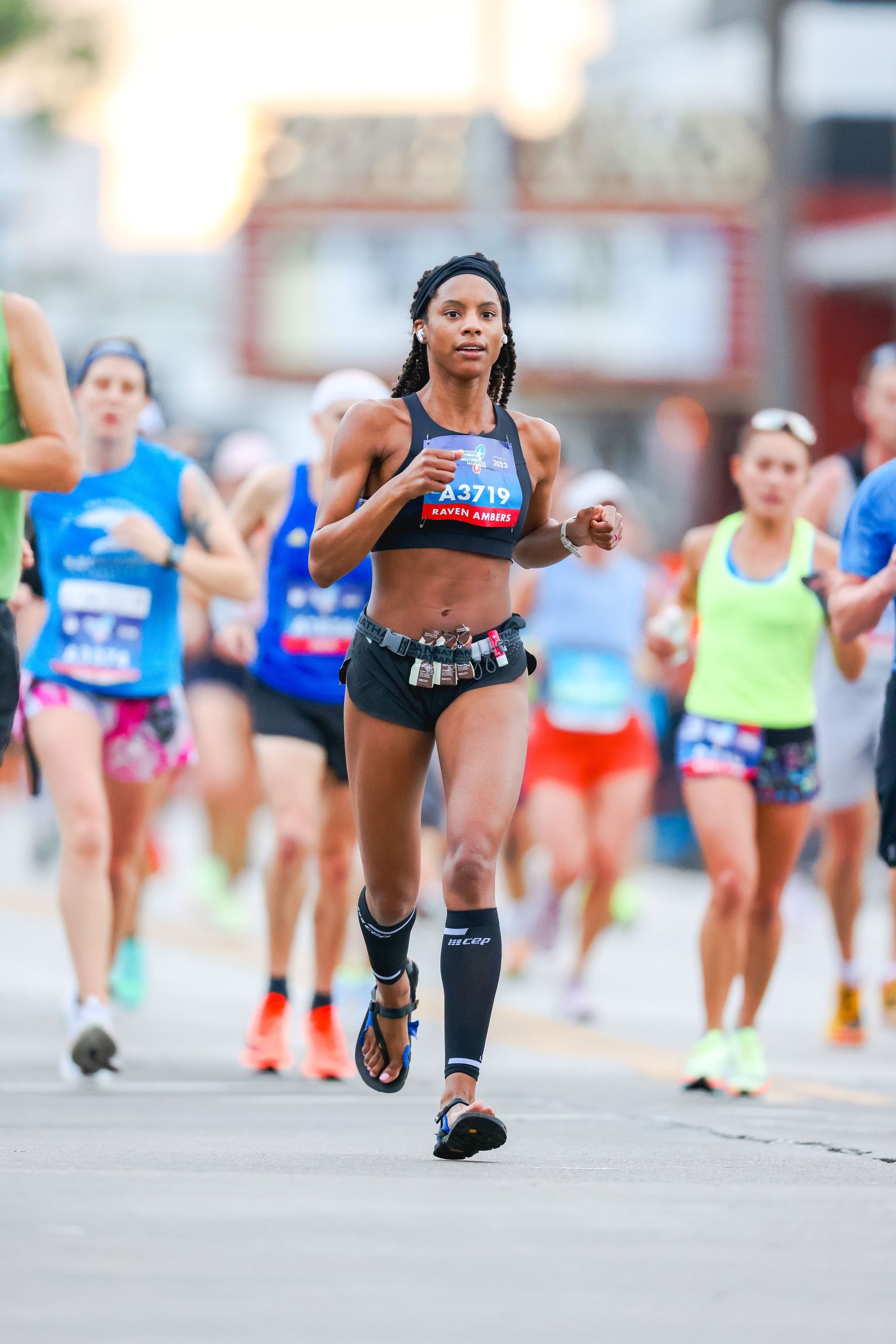Female runner with race bib A3719 competing in urban street marathon race.
