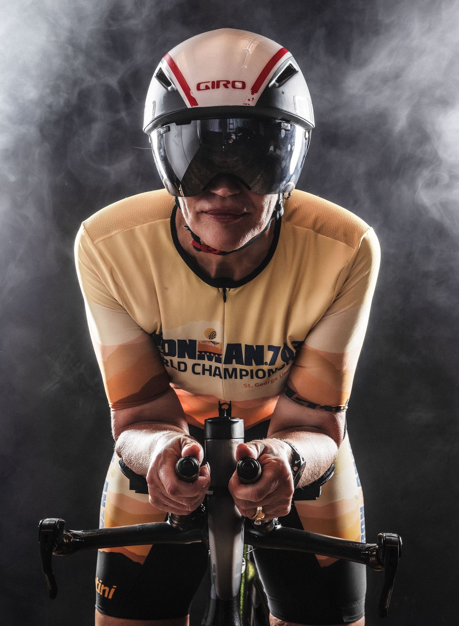 Cyclist in Giro aero helmet and Ironman 70.3 World Championship kit rides in aggressive time trial position.