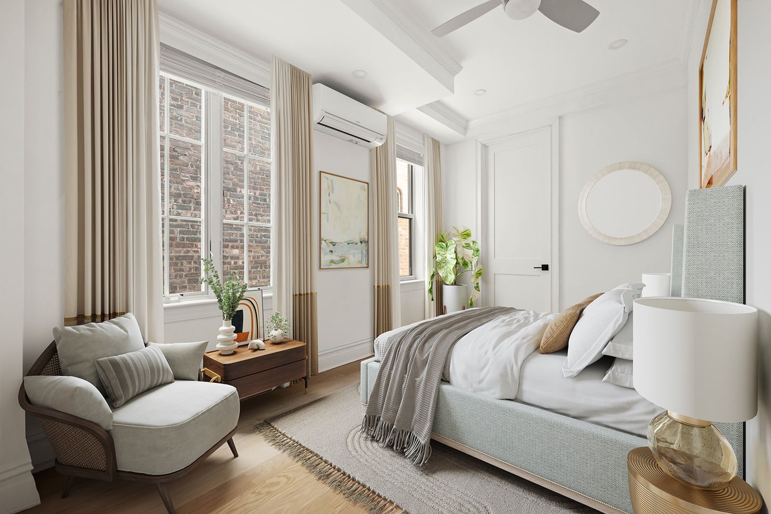 Elegant bedroom with gray upholstered bed, ceiling fan, tall windows with drapes, and cozy armchair on hardwood floors.