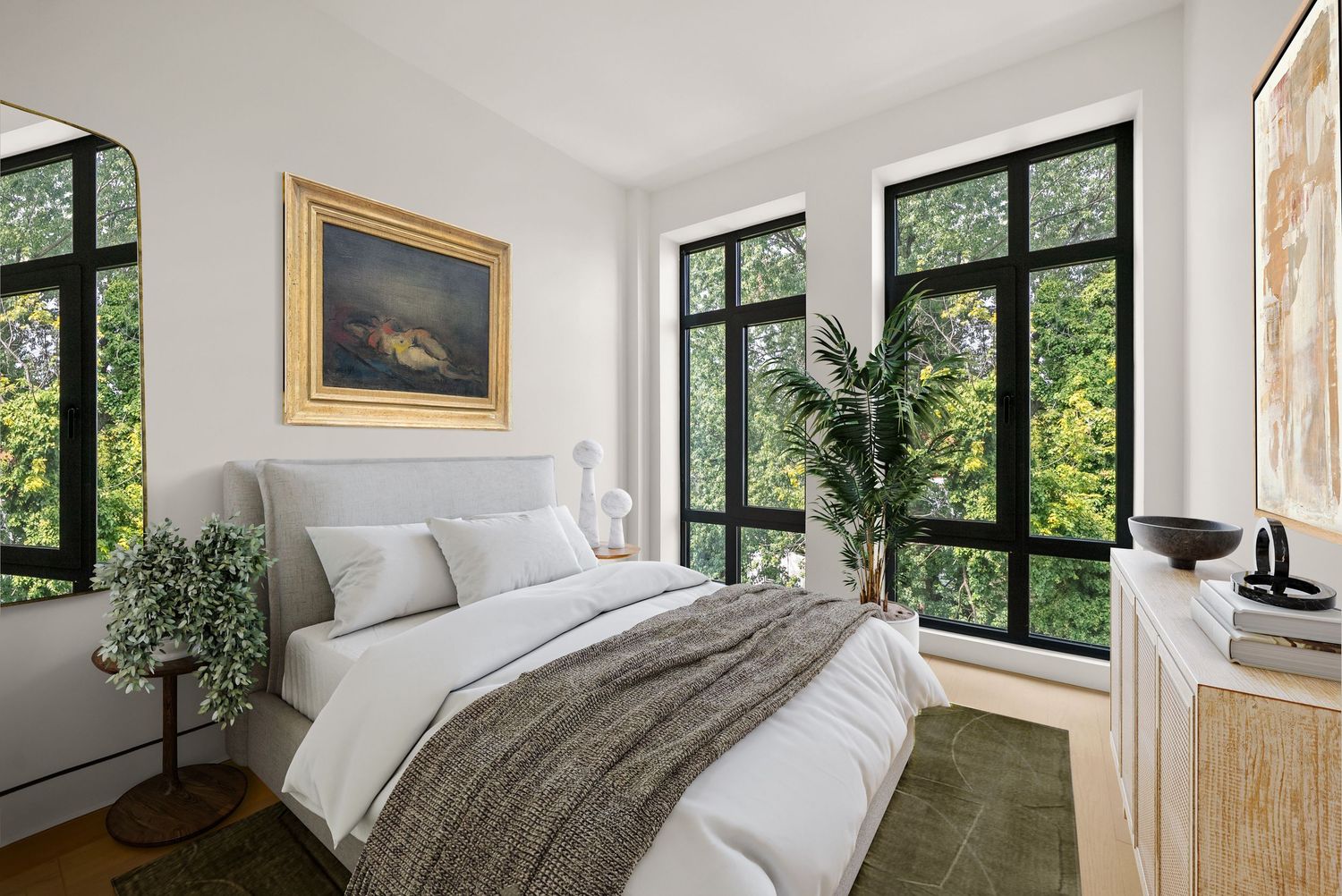 Bright bedroom with black-framed windows, lush greenery views, white bedding, gold-framed art, and natural wood dresser.