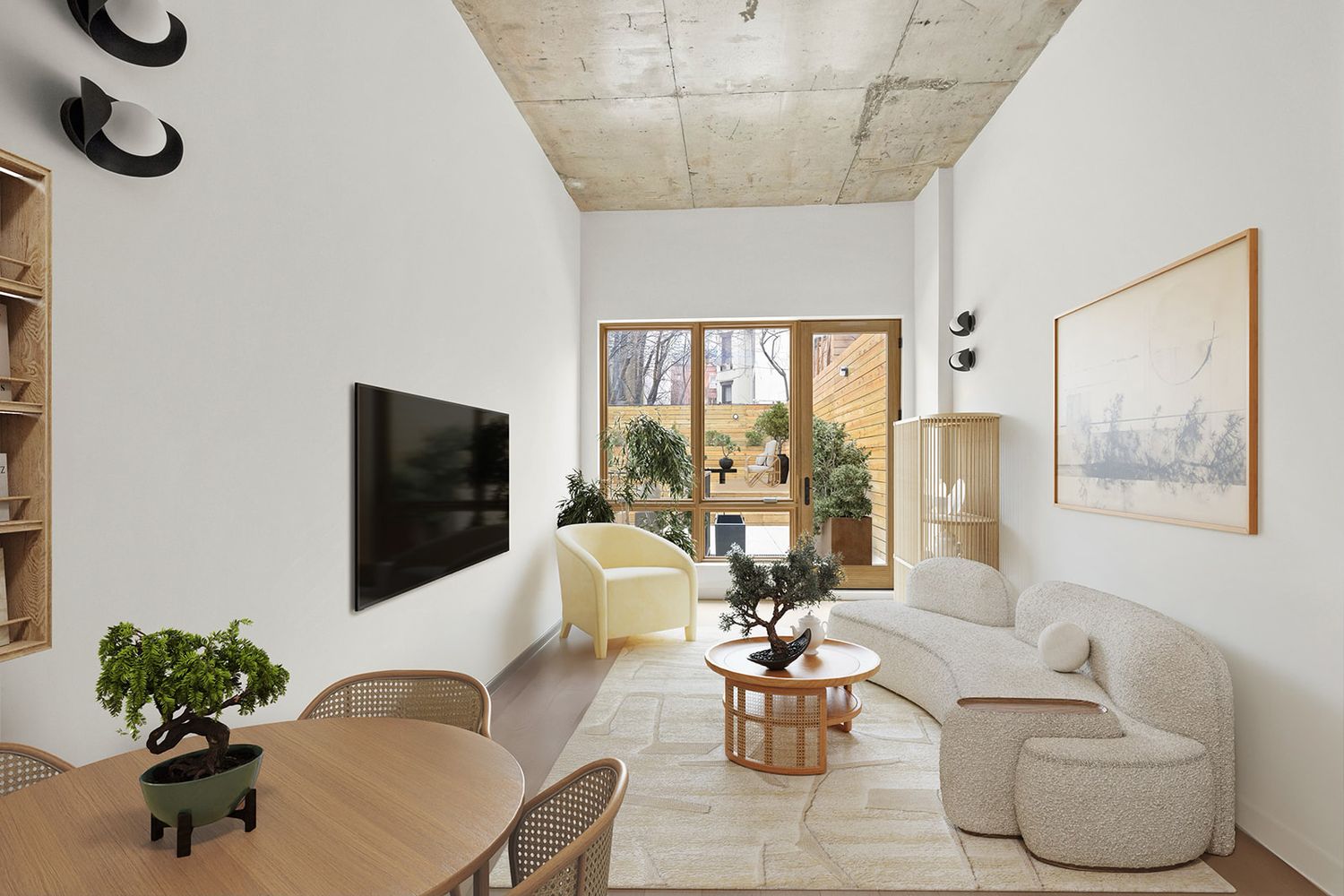 Modern living room with white sofa, bonsai tree, wood coffee table, and large window overlooking a garden.