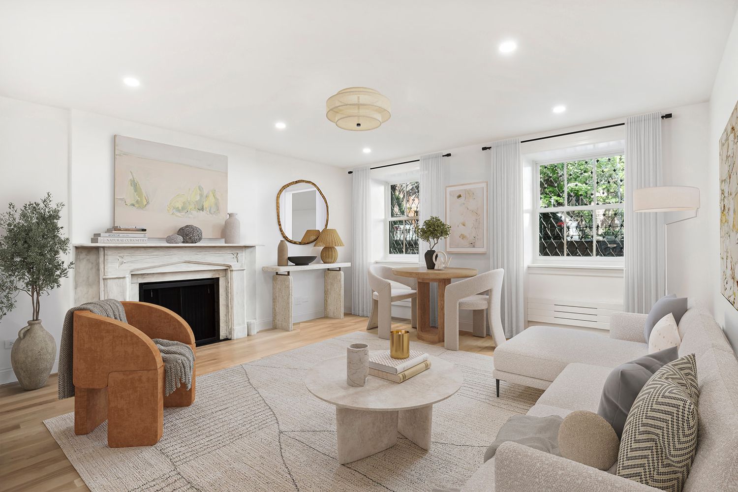 Bright living room with white walls, hardwood floors, fireplace, neutral sofa, rattan chairs, and round coffee table.