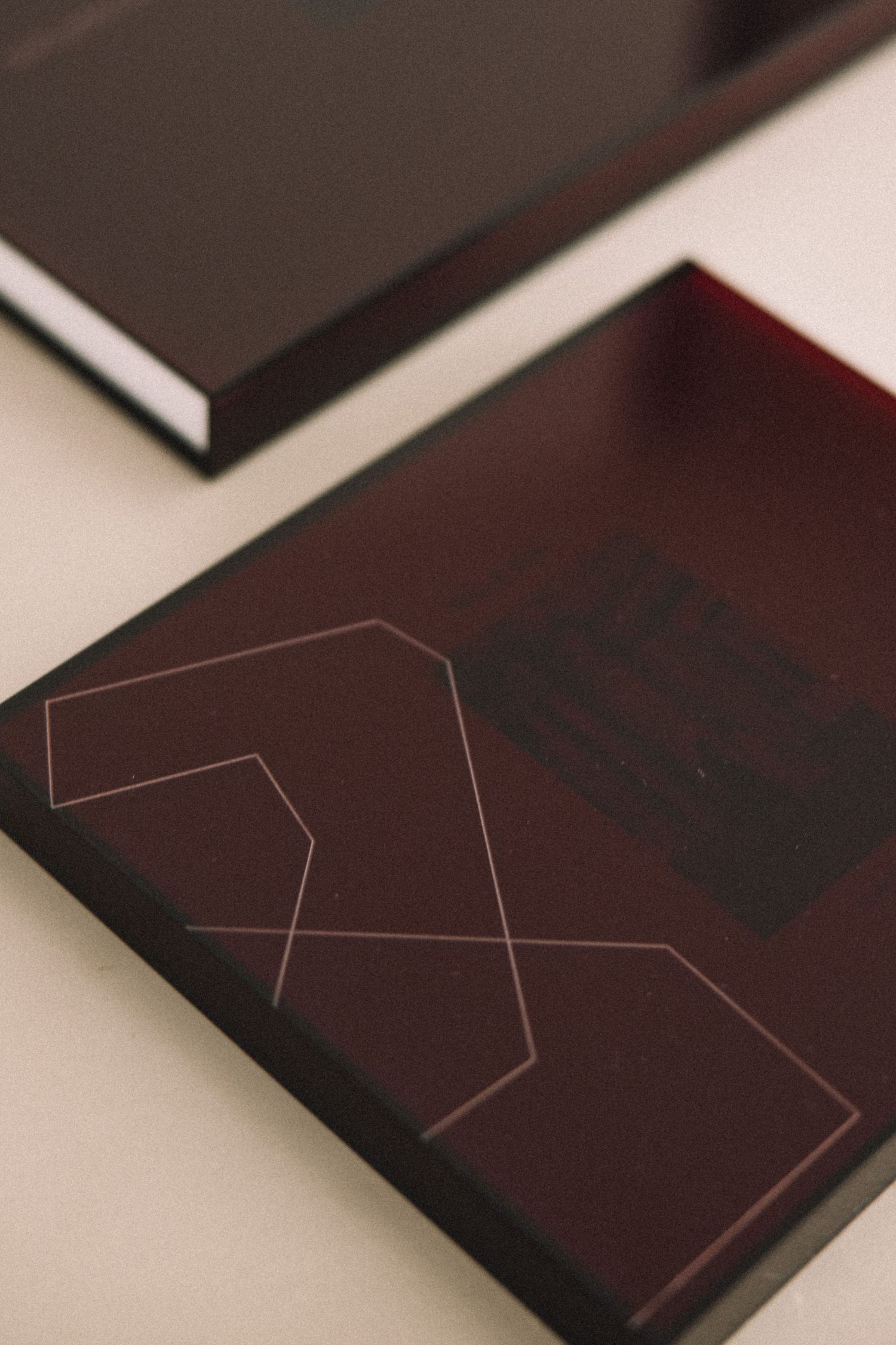 Dark burgundy book with geometric line design on cover, displayed on light surface.