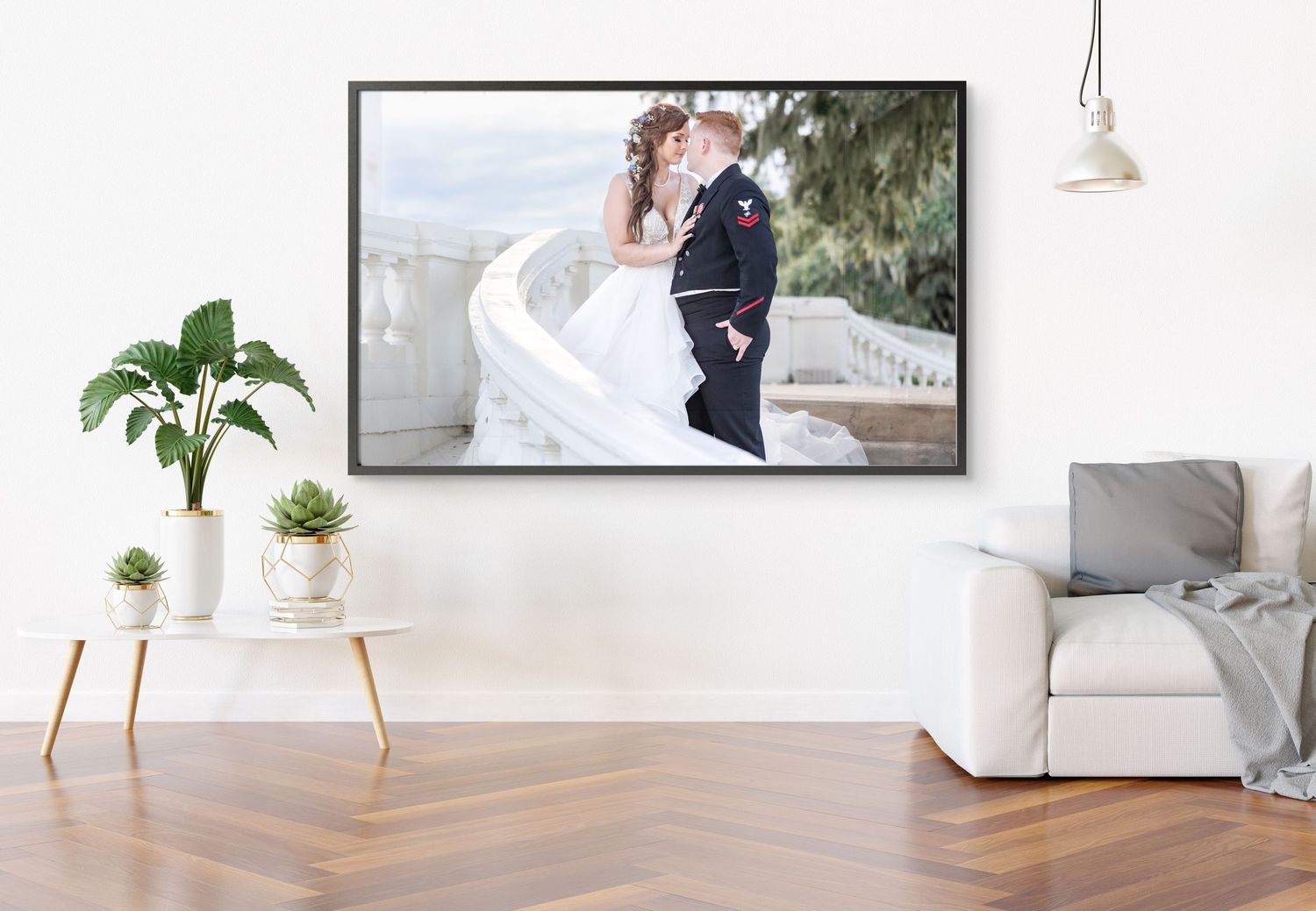 Framed wedding photo of kissing couple displayed above sofa in modern living room.