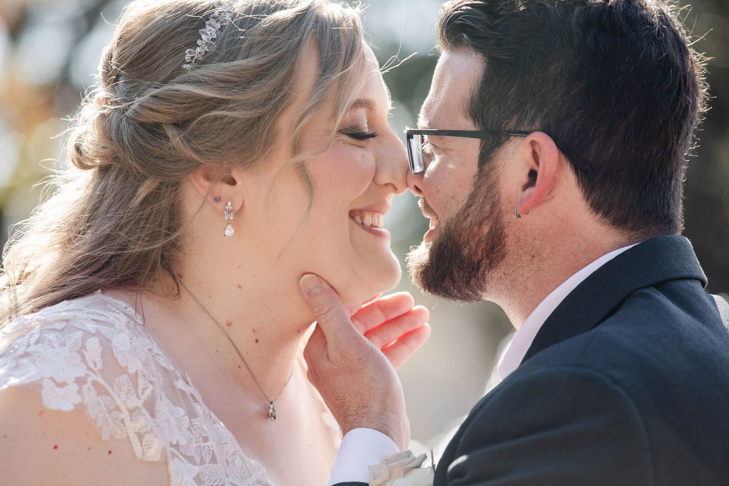 Bride and bearded groom sharing intimate close moment smiling nose to nose.