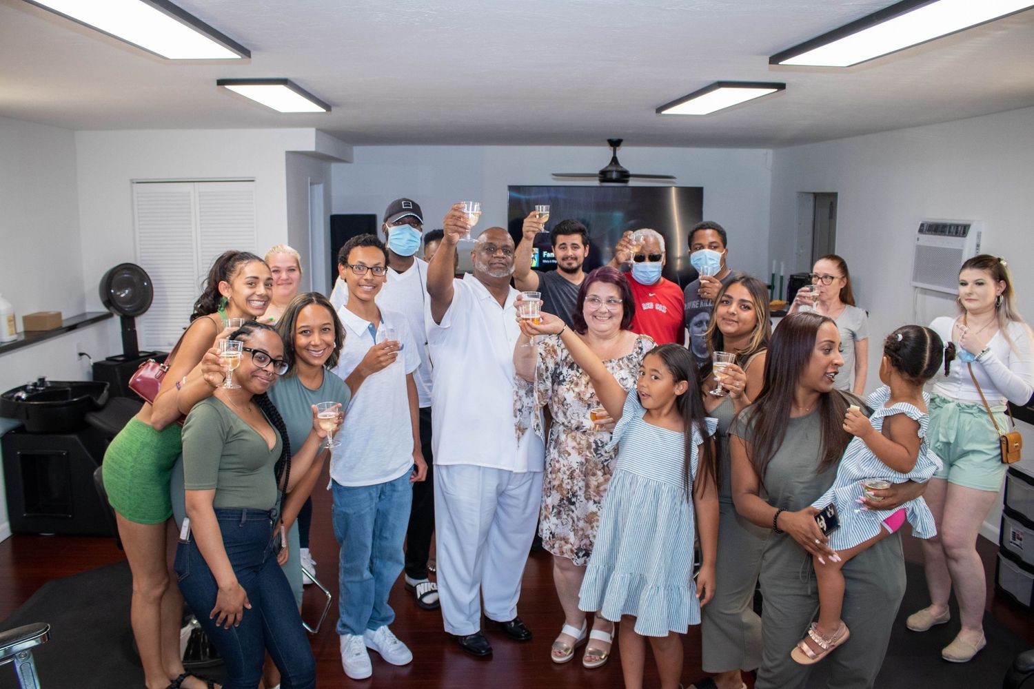 Large diverse group of smiling people posing together for a photo at an indoor gathering or party.