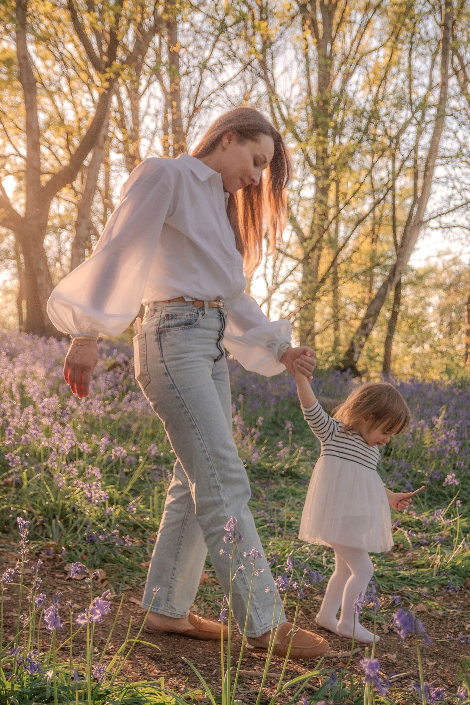 Mother and daughter walking in woods.