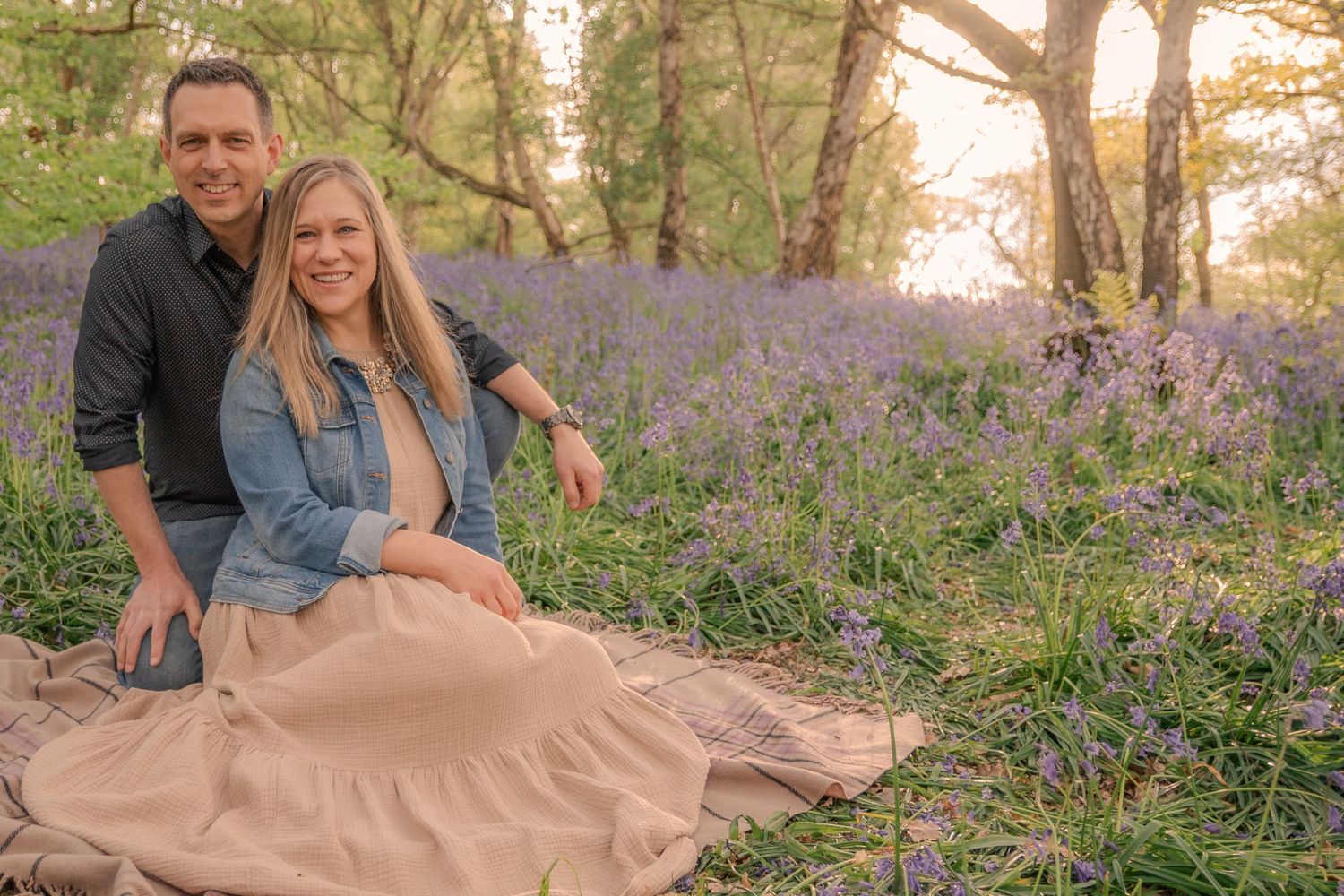 Husband and wife sitting in forest.