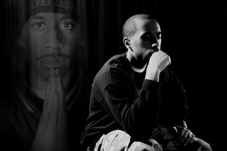 Black and white portrait of a man in contemplative pose with a ghostly figure praying in background.