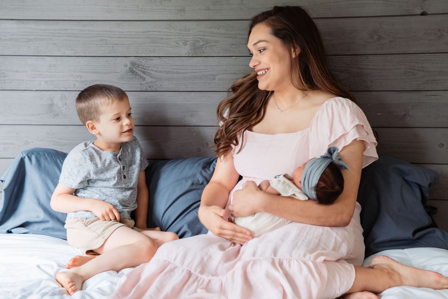 Family lifestyle portraits on gray wood backdrop showing tender moments together.