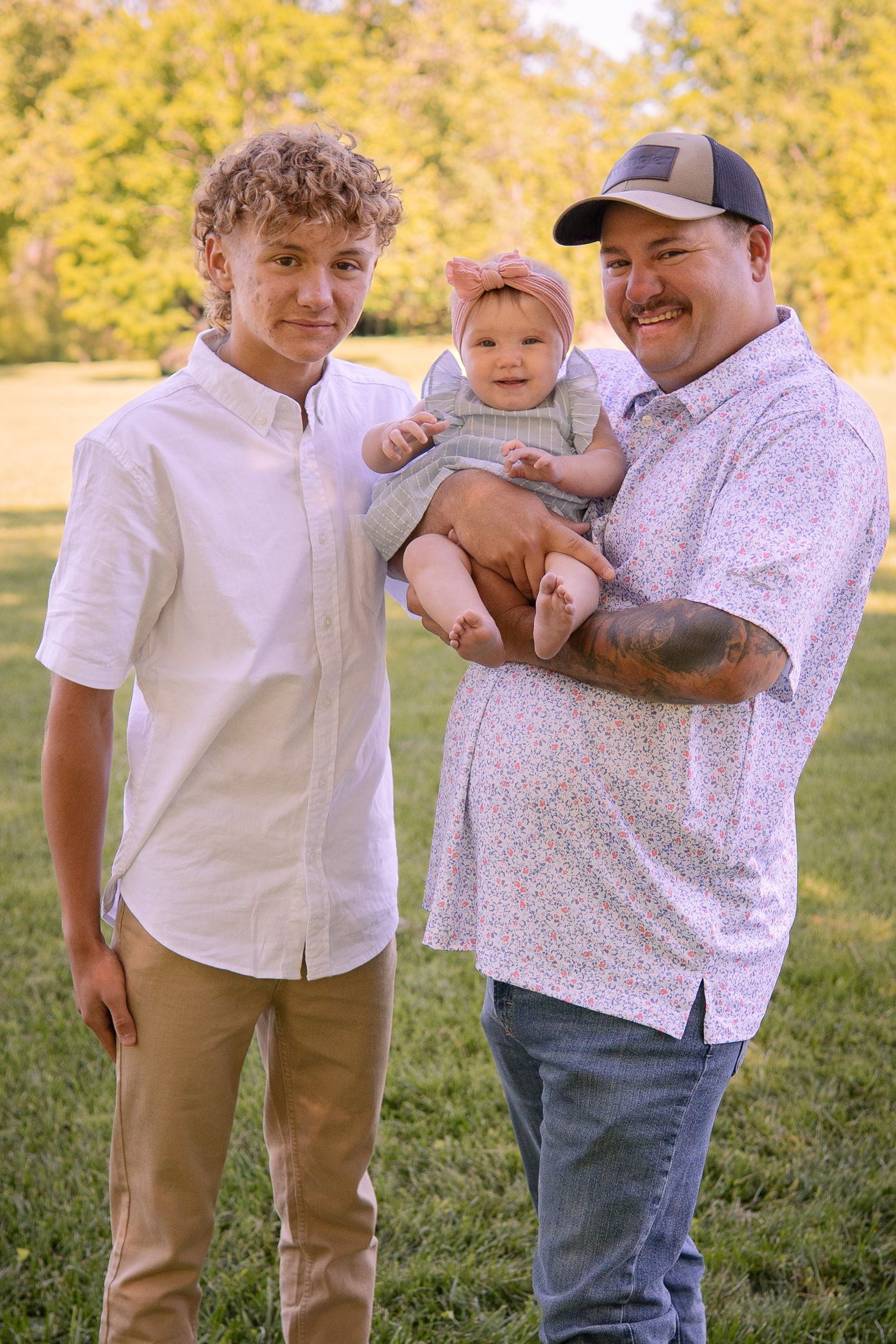 A heartwarming outdoor family portrait with autumn trees creating a golden backdrop.