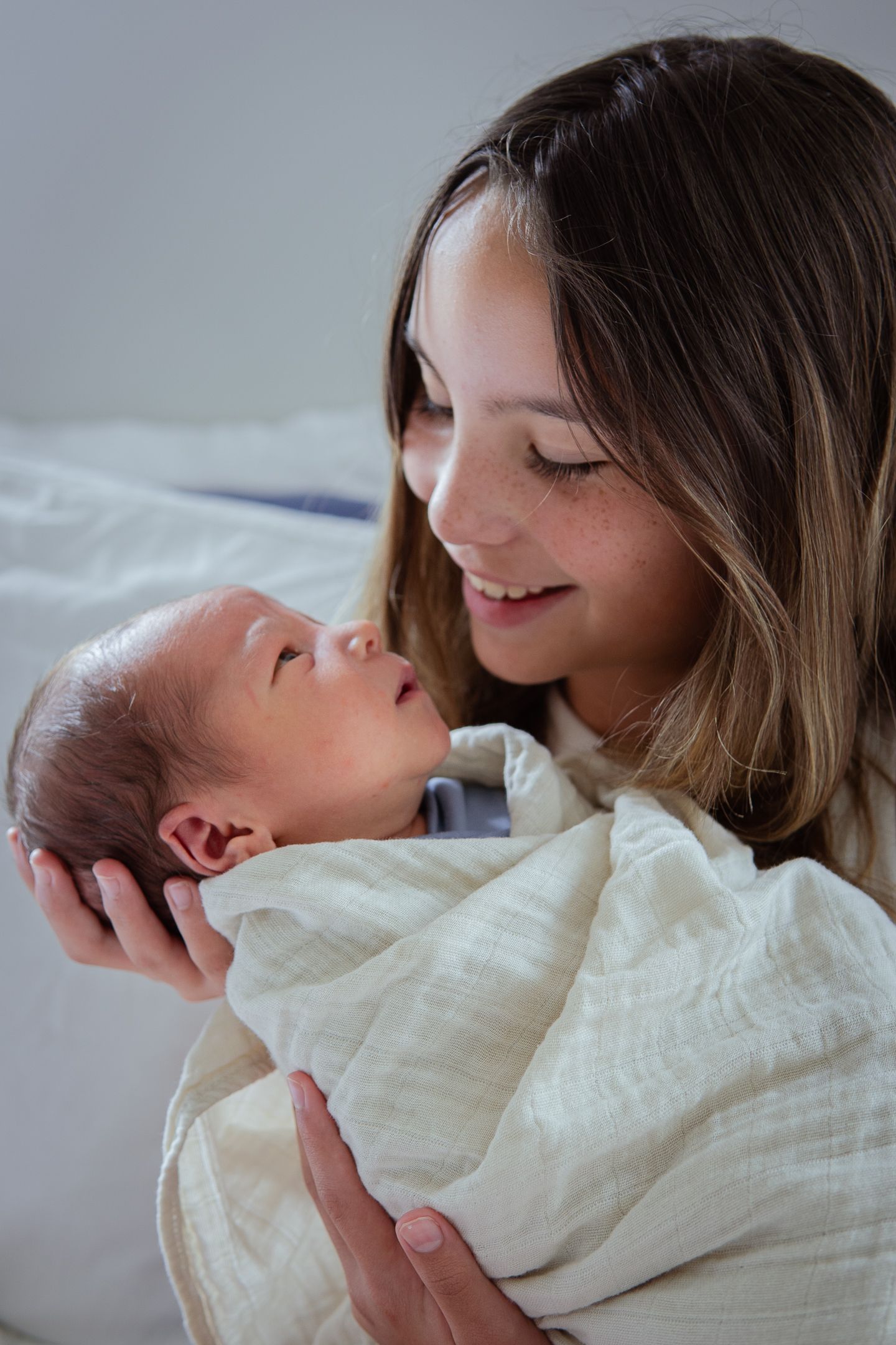 A series showing joyful bonding moments between parent and newborn in soft lighting.
