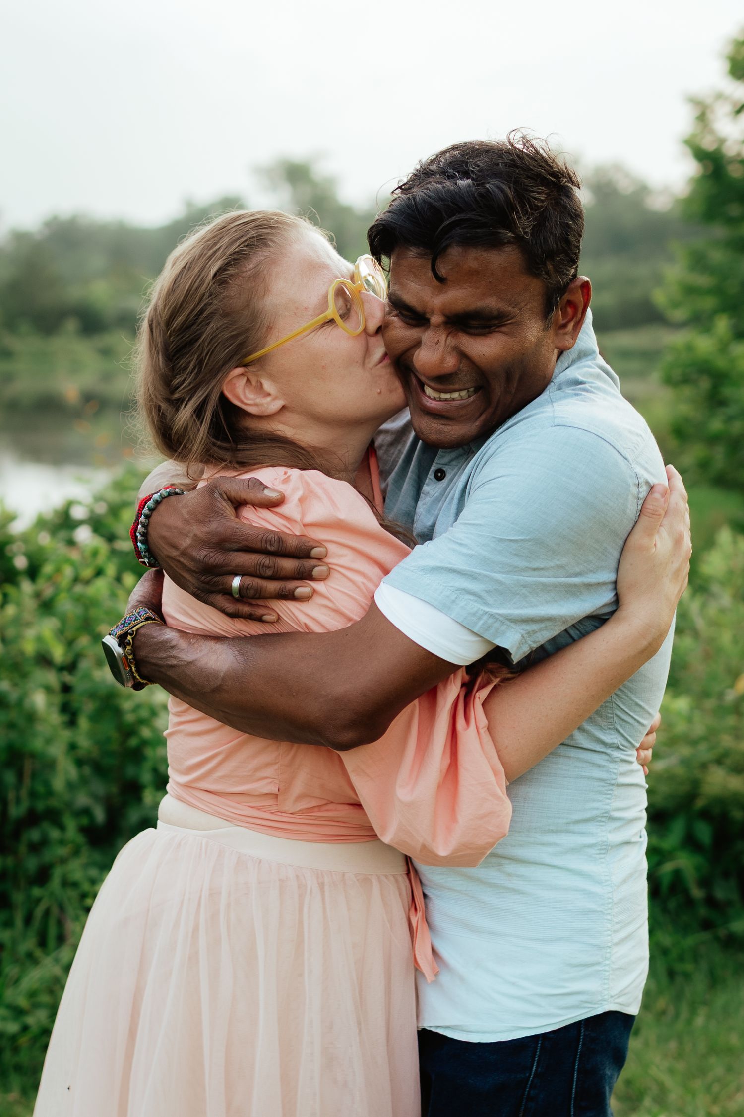 A couple embraces and shares affectionate moments in a natural outdoor setting.