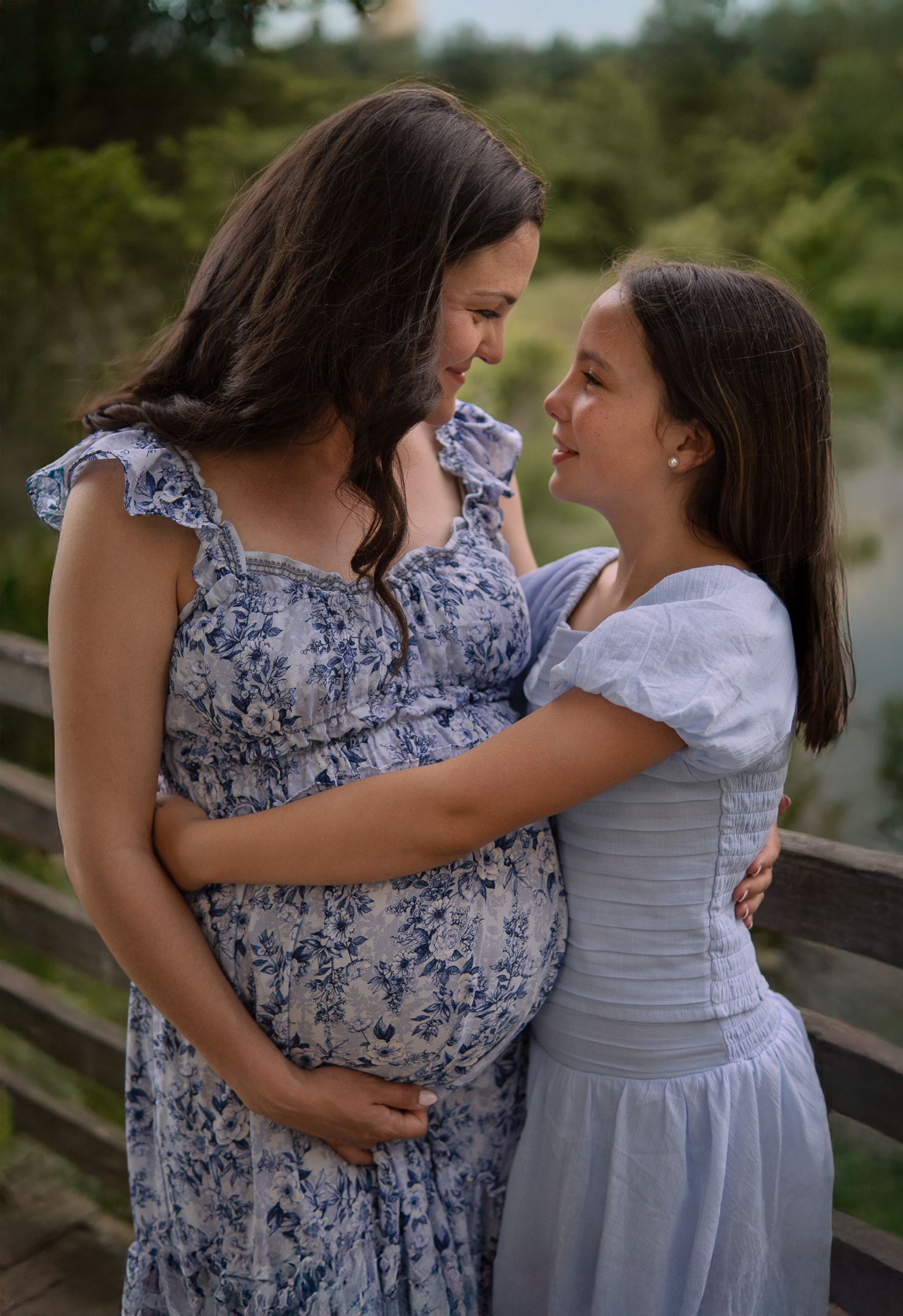 A touching family moment captured outdoors showing a mother in a floral dress with her child.