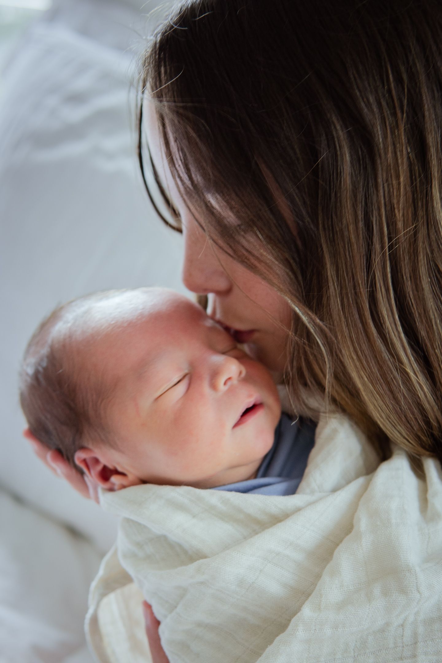 Gentle sequence showing a parent sharing loving moments with a sleeping newborn.