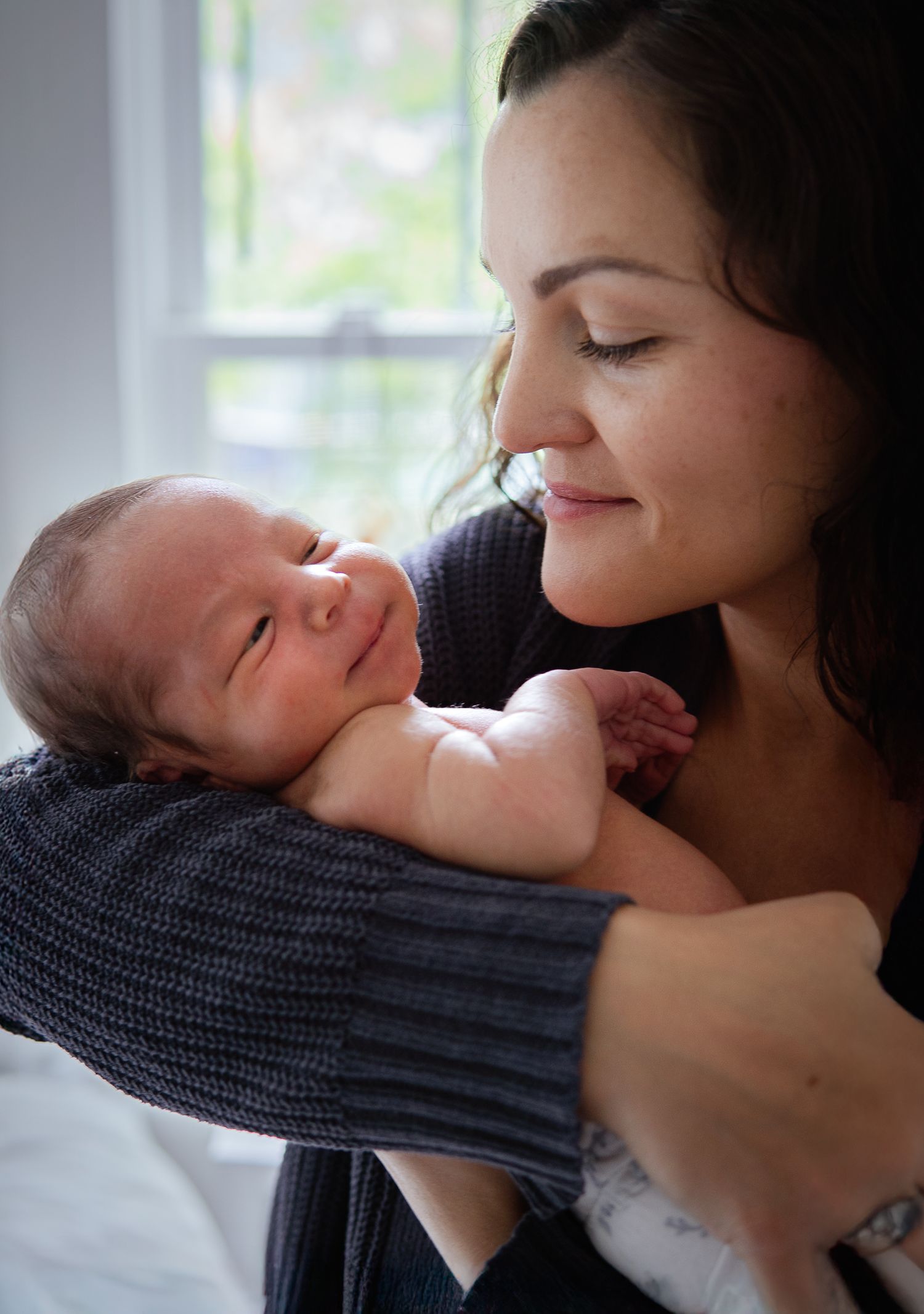 Natural light portraits capturing gentle interactions between parent and baby.