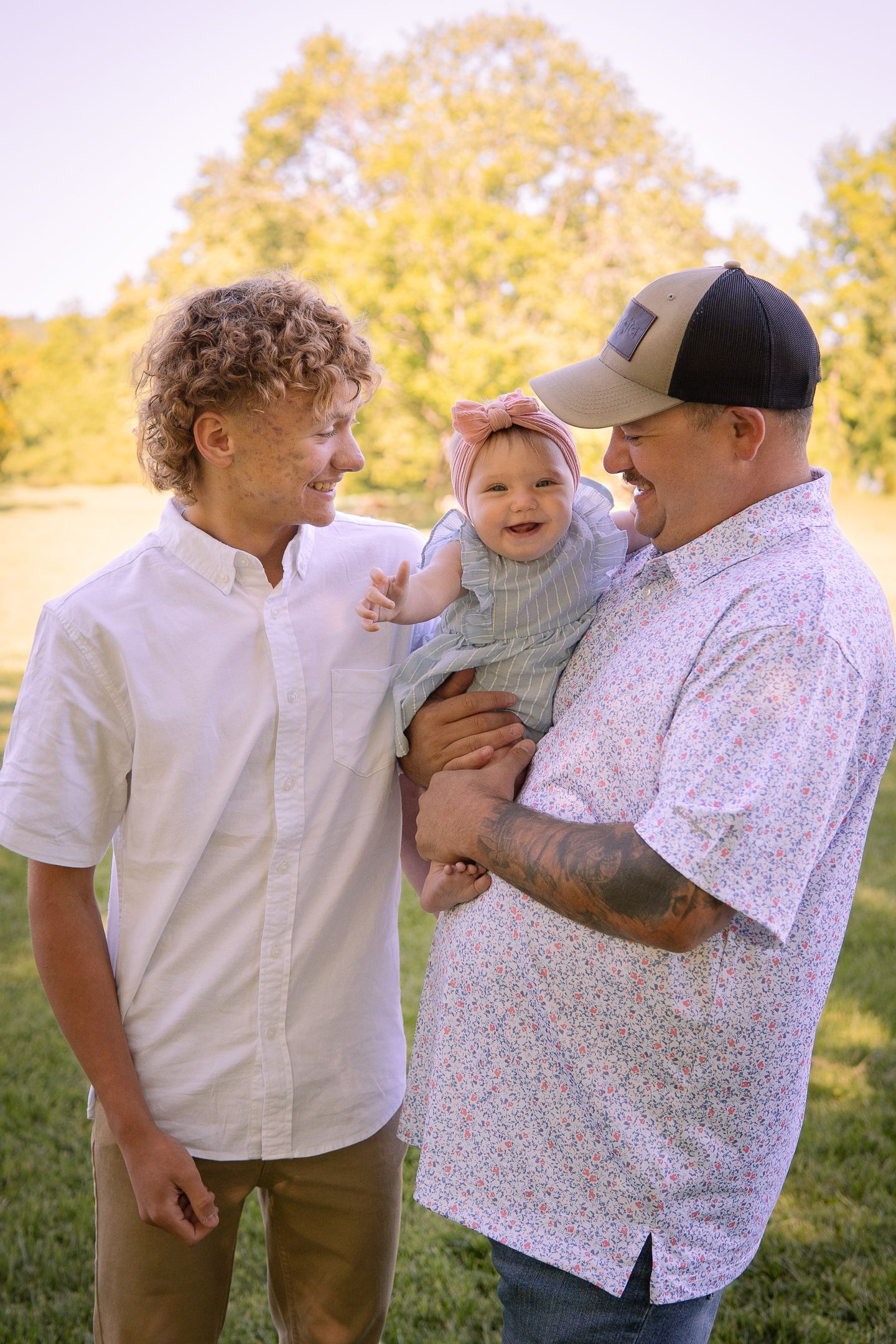 Three generations share joyful smiles and laughter outdoors on a sunny autumn day.