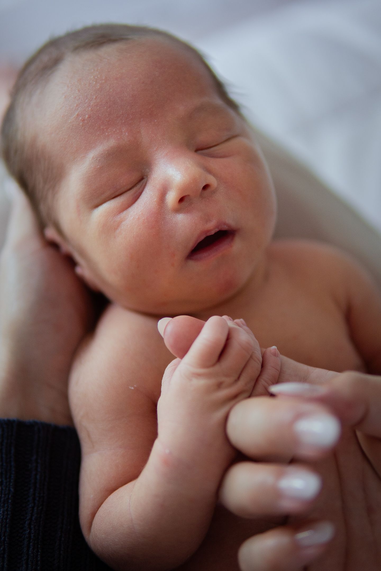 Close-up portraits of a sleeping newborn with peaceful expressions.