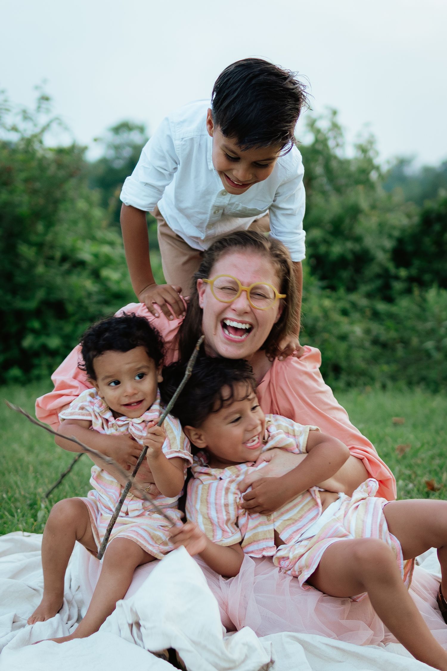 A family shares joyful laughter while cuddling together outdoors.