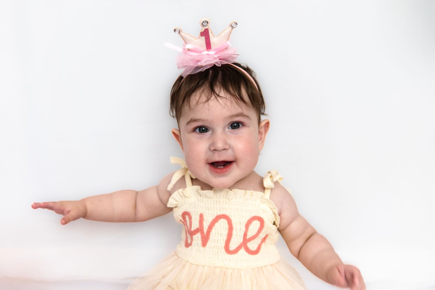 Baby wearing a peach-colored dress with 