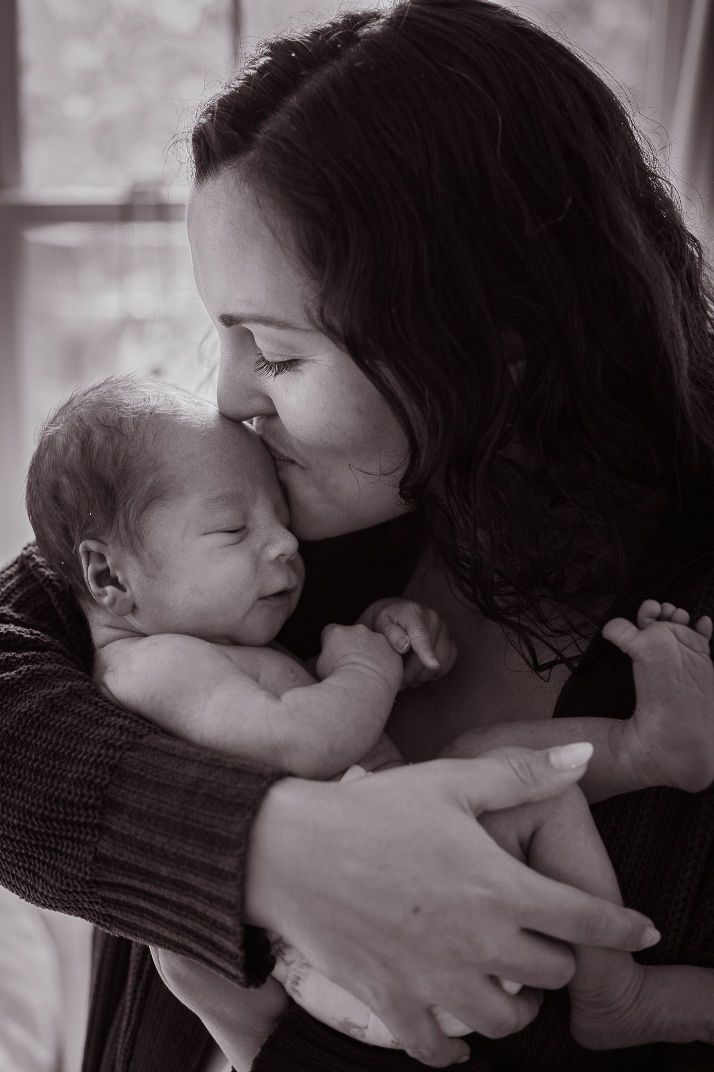 Black and white series showing tender moments between parent and newborn.