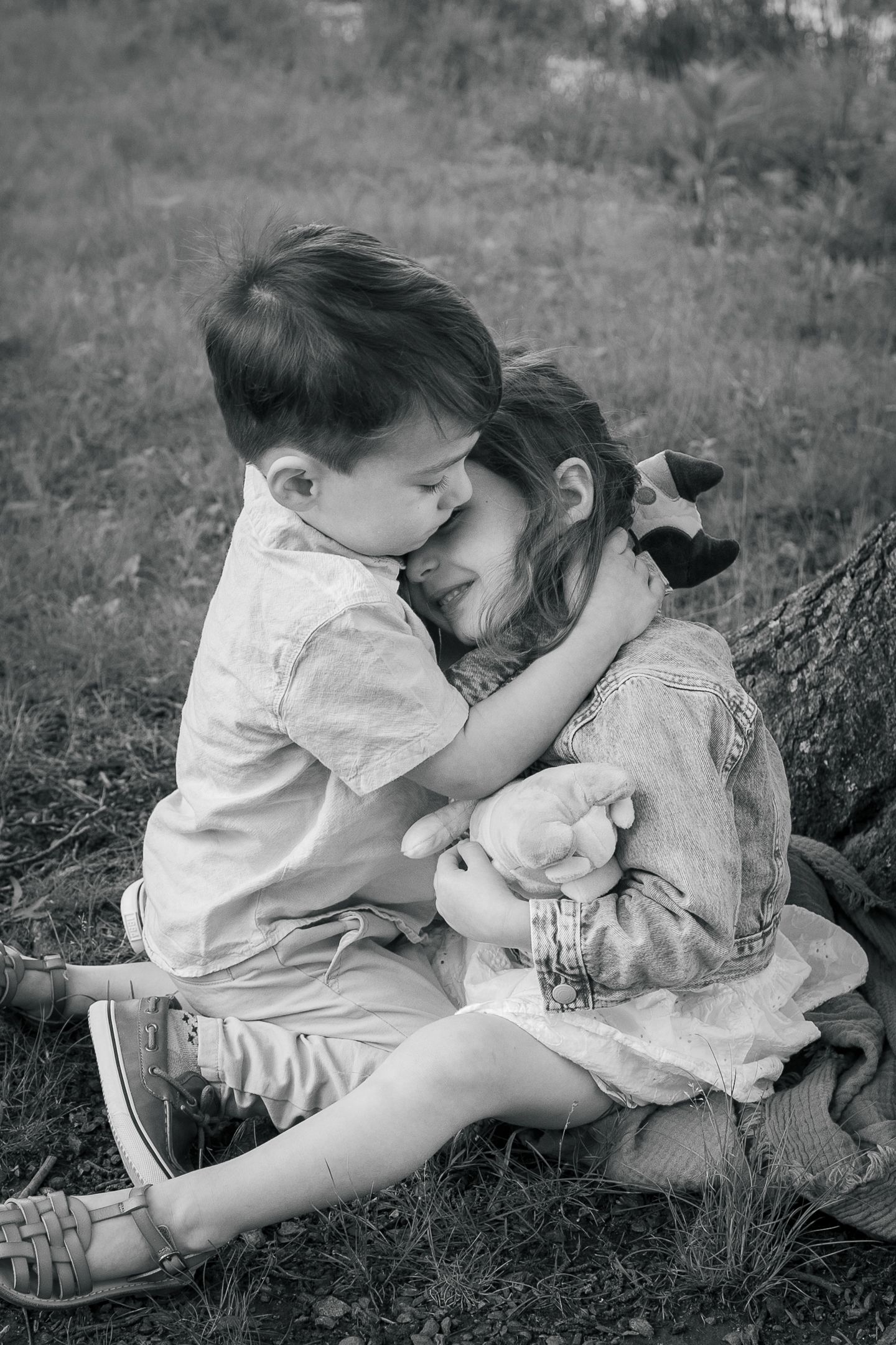 Black and white candid photo capturing sweet embraces and genuine moments between two people.