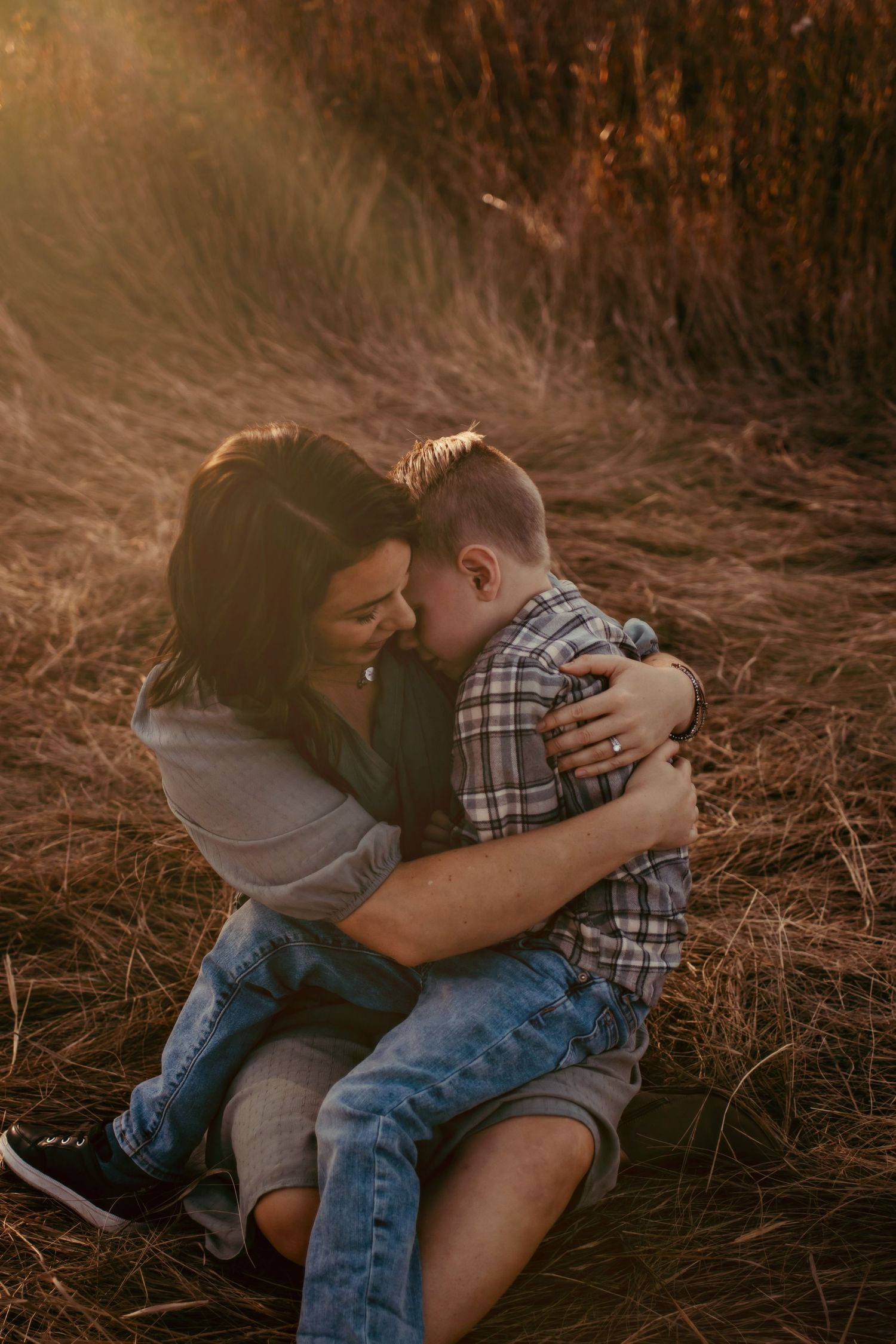 Intimate moment between two people embracing in golden sunlight.