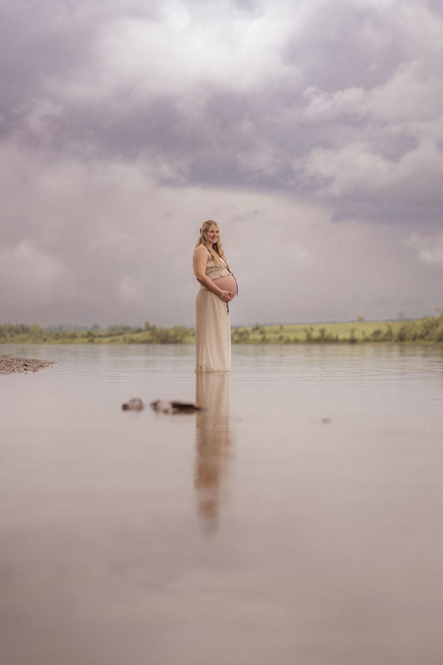 A dreamy sequence of five ethereal photos showing a person in flowing dress standing in misty water under moody clouds.