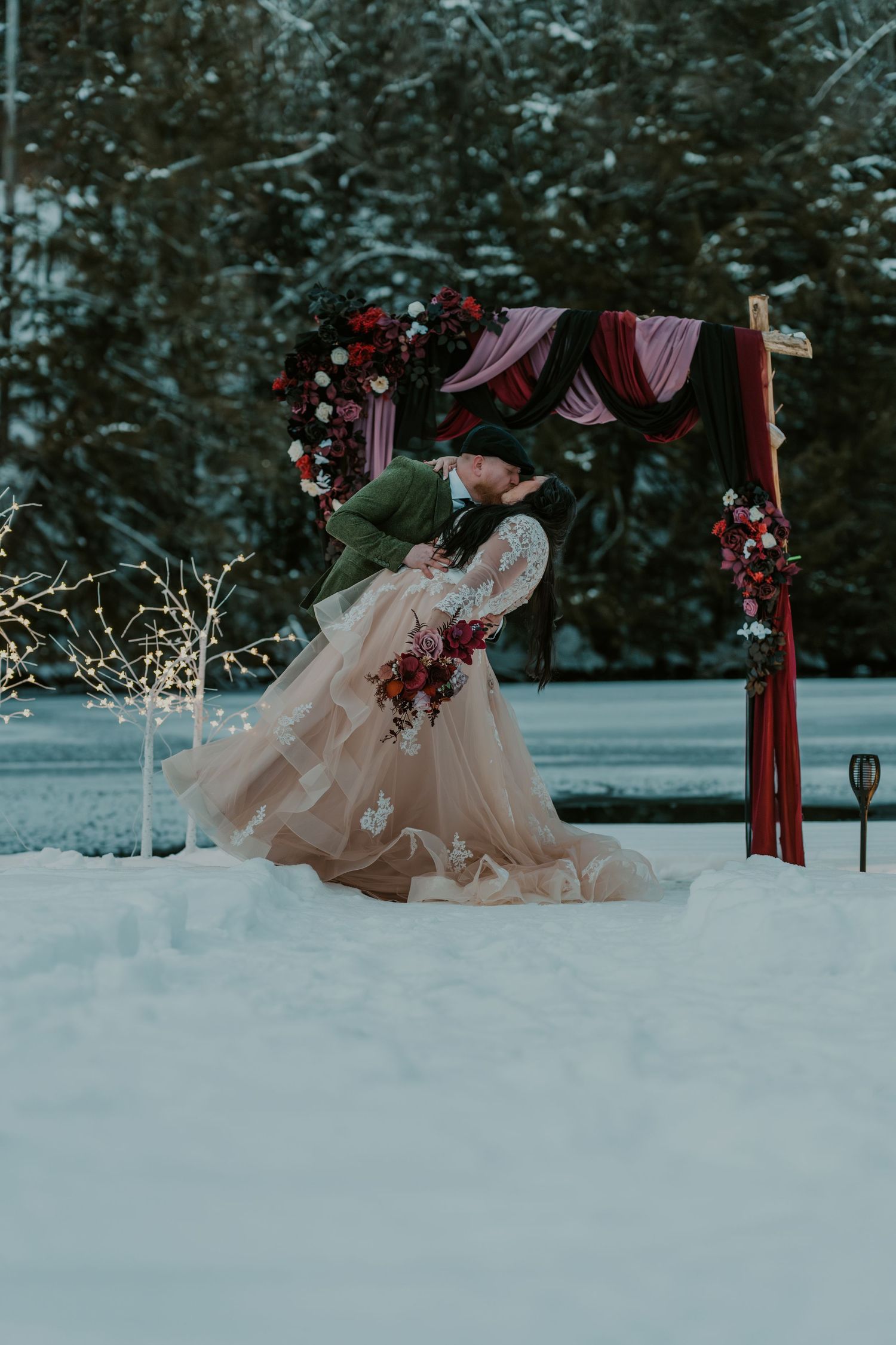 A dreamy winter scene featuring a blush-colored dress against snowy forest backdrop.