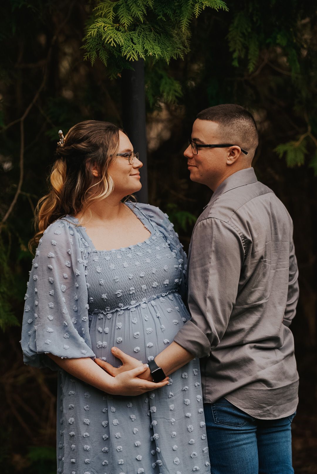 Intimate couple photos showing affectionate poses against natural greenery backdrop.