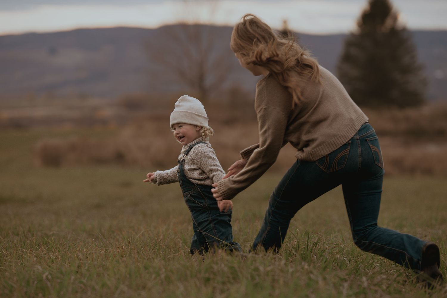 Playful moments captured between family members in an open field at sunset.