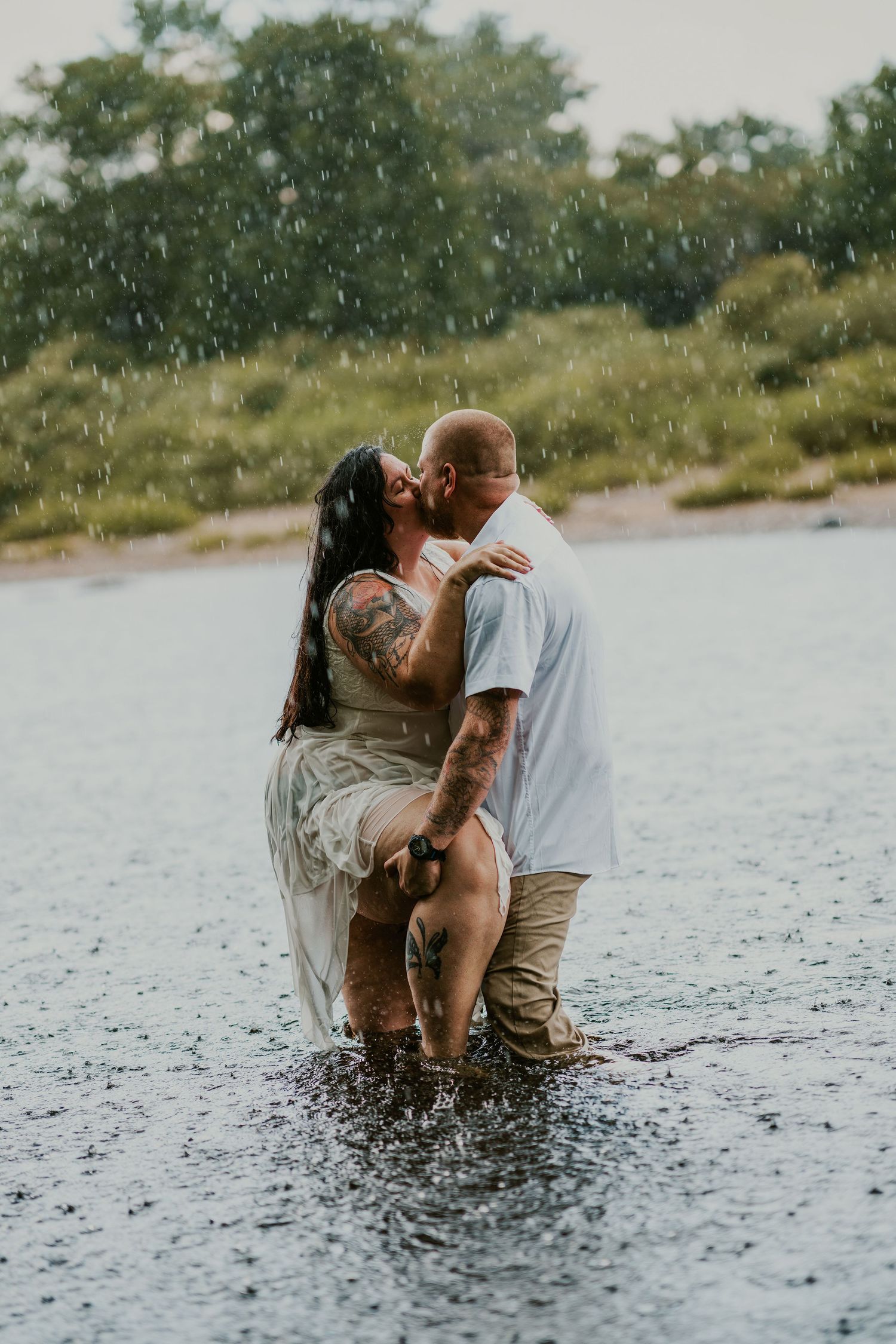 Romantic couple's photoshoot in shallow water showing intimate moments.