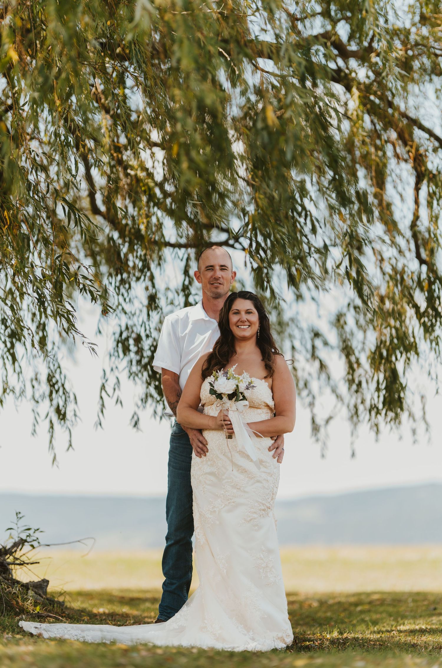Romantic moments under a weeping willow tree in golden sunlight.