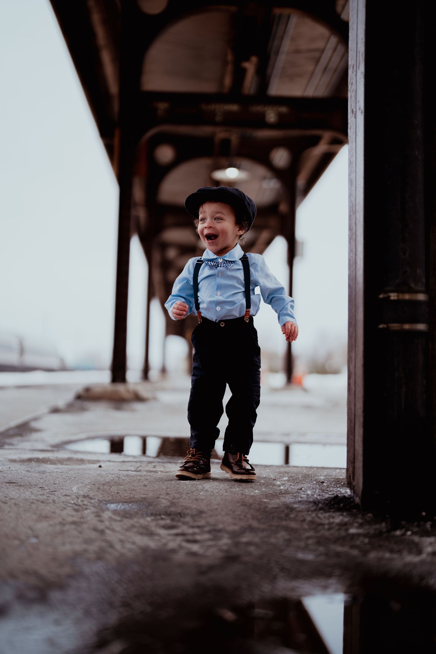 A playful sequence shows a child in suspenders exploring under a covered walkway.